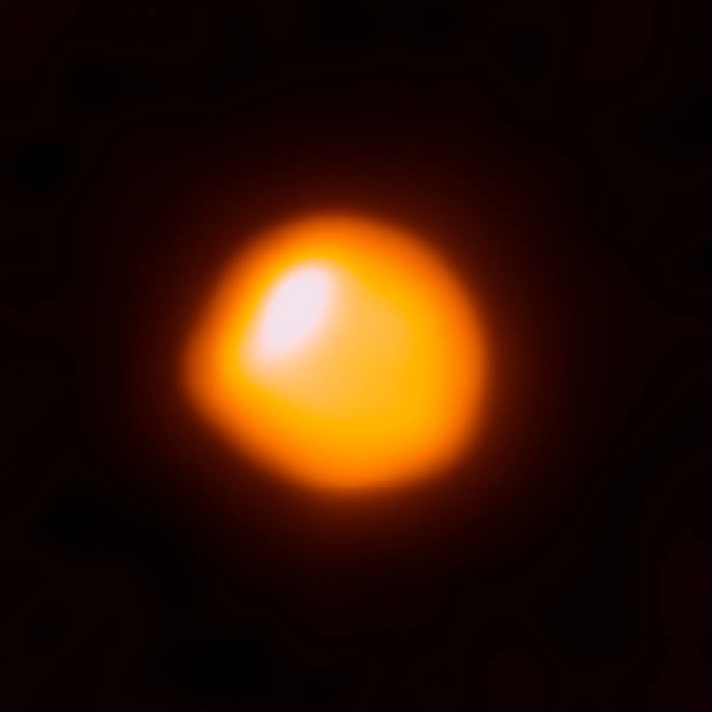 アルマ望遠鏡がとらえた赤色超巨星ベテルギウス。オレンジ色の円盤の左上に明るい部分がある