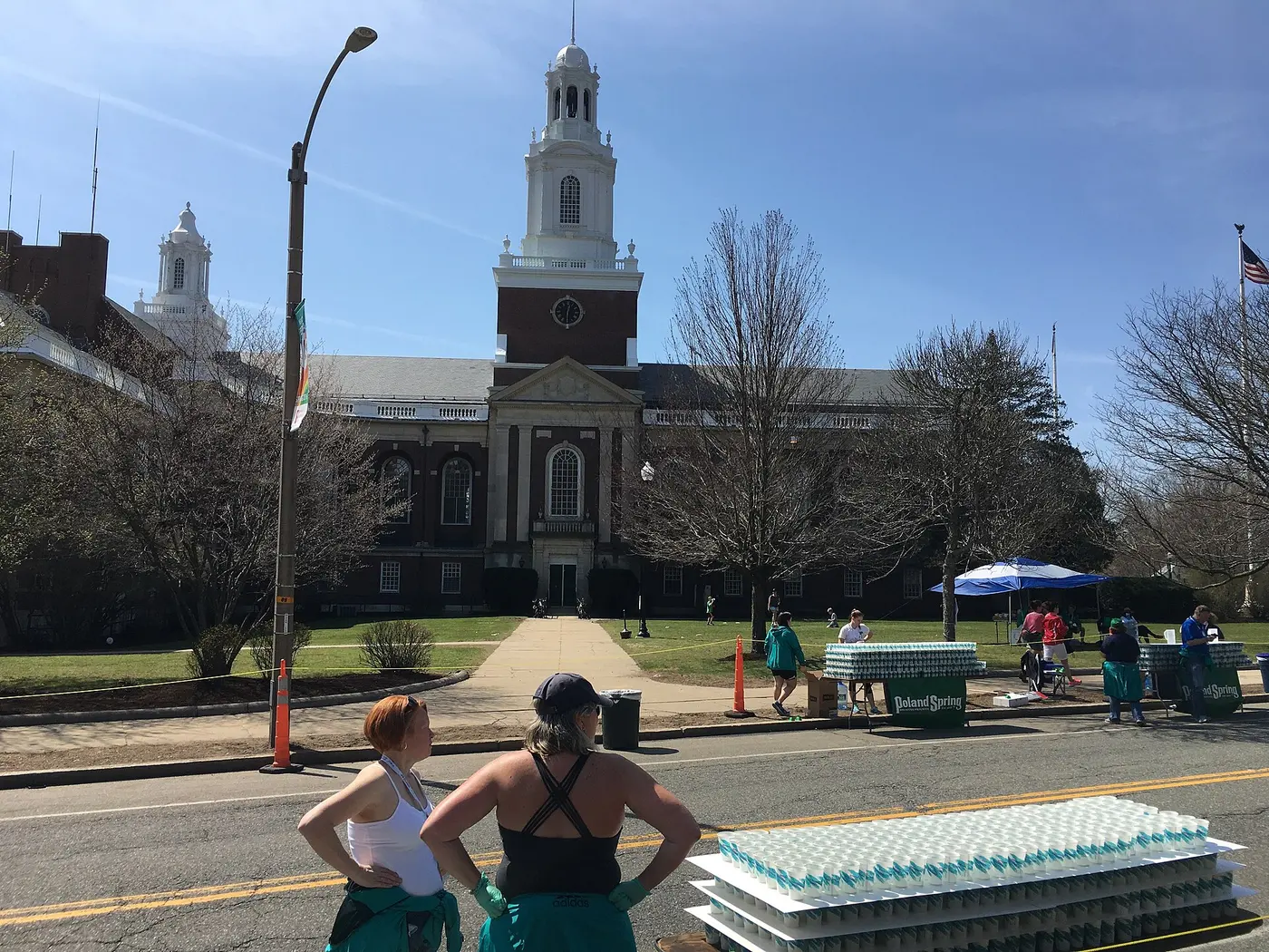 Paper cups of water packed tightly on tables by the roadside, with two women standing in front