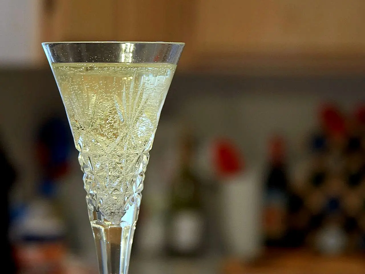 Pale gold sparkling wine poured into cut-glass flutes, with fine bubbles rising