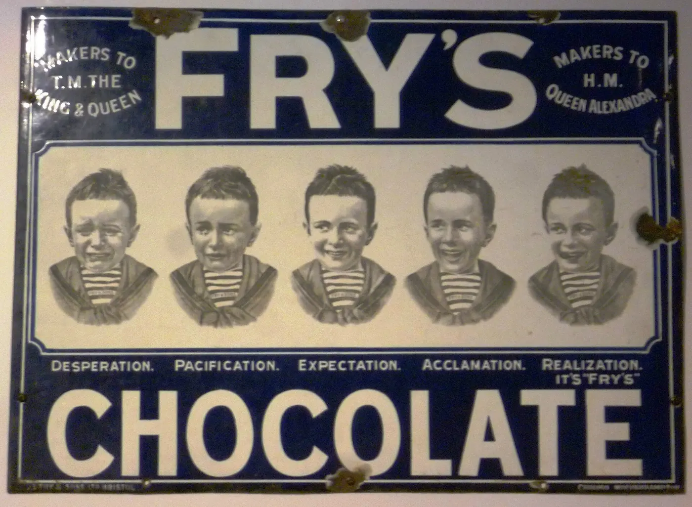 A blue enamel sign showing five boys’ faces with different expressions and the words “FRY’S CHOCOLATE” in large letters