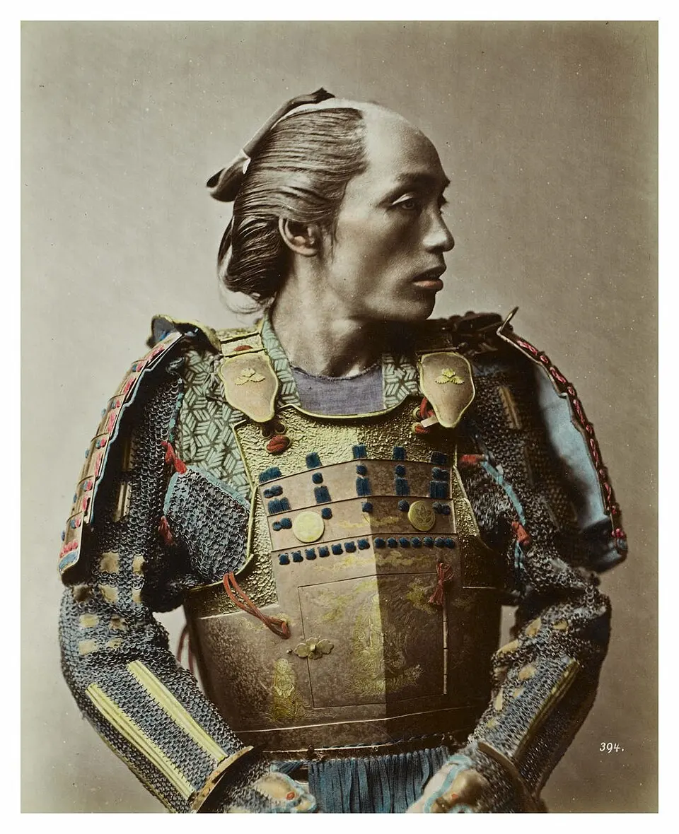 Hand-colored photograph of a man in armor with a shaved crown and a topknot