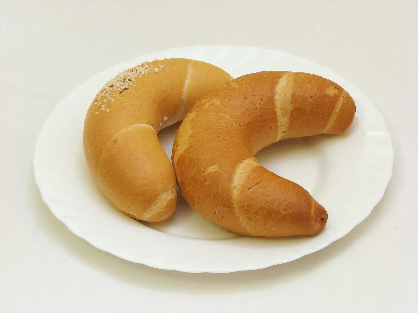 Two golden-brown crescent-shaped rolls on a white plate