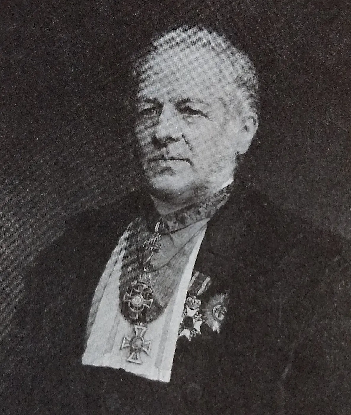 Black-and-white portrait of a white-haired man wearing medals