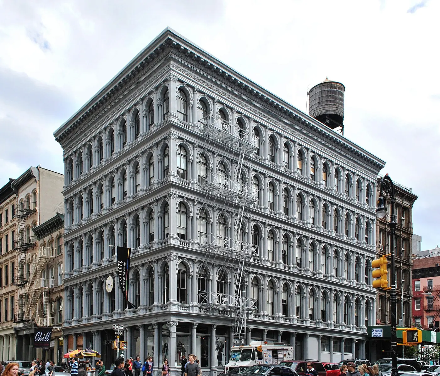 A gray five-story building with rows of cast-iron arched windows