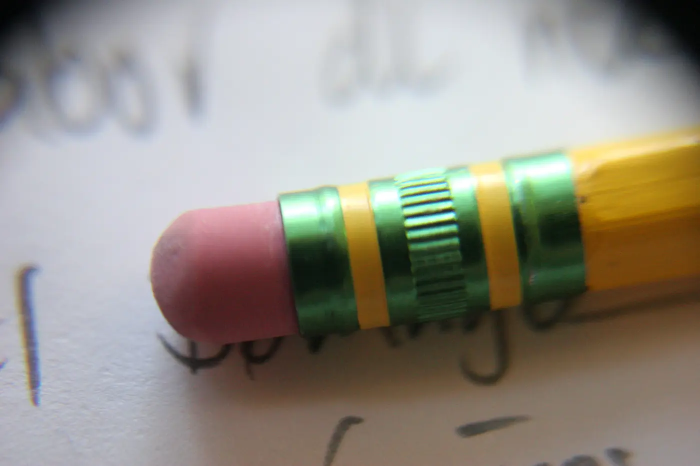 A pink eraser attached to the end of a pencil with a metal band