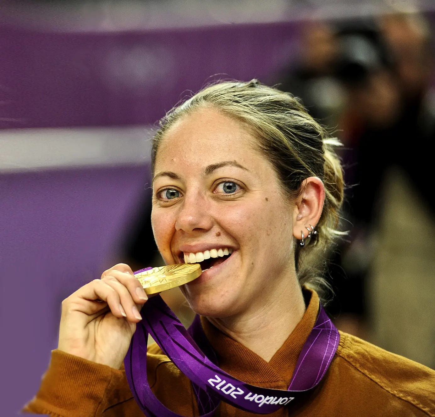 Jamie Lynn Gray, winner of a shooting event at the London Olympics, posing as she bites her gold medal