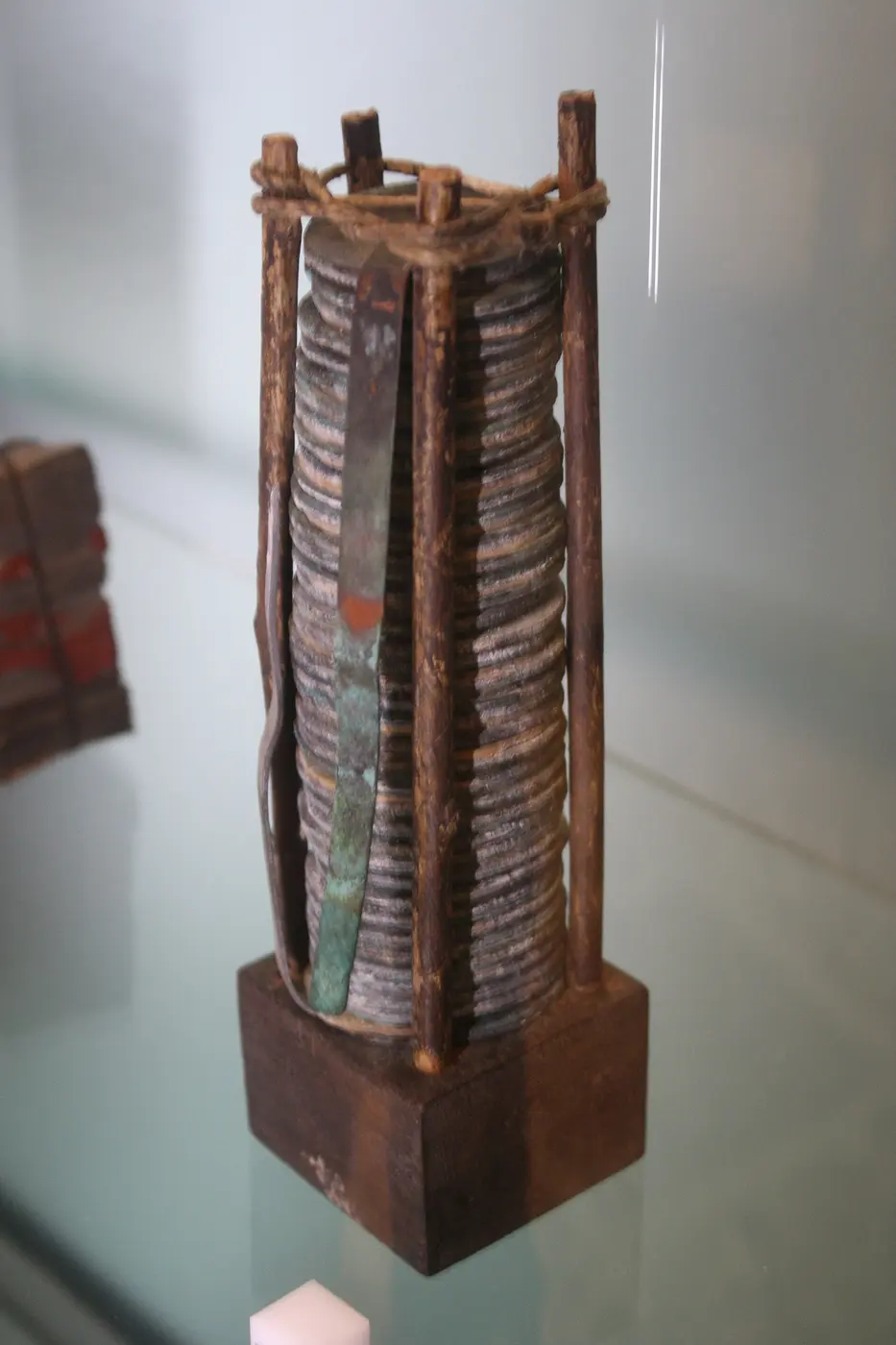 A device made of dozens of metal discs stacked inside a wooden frame