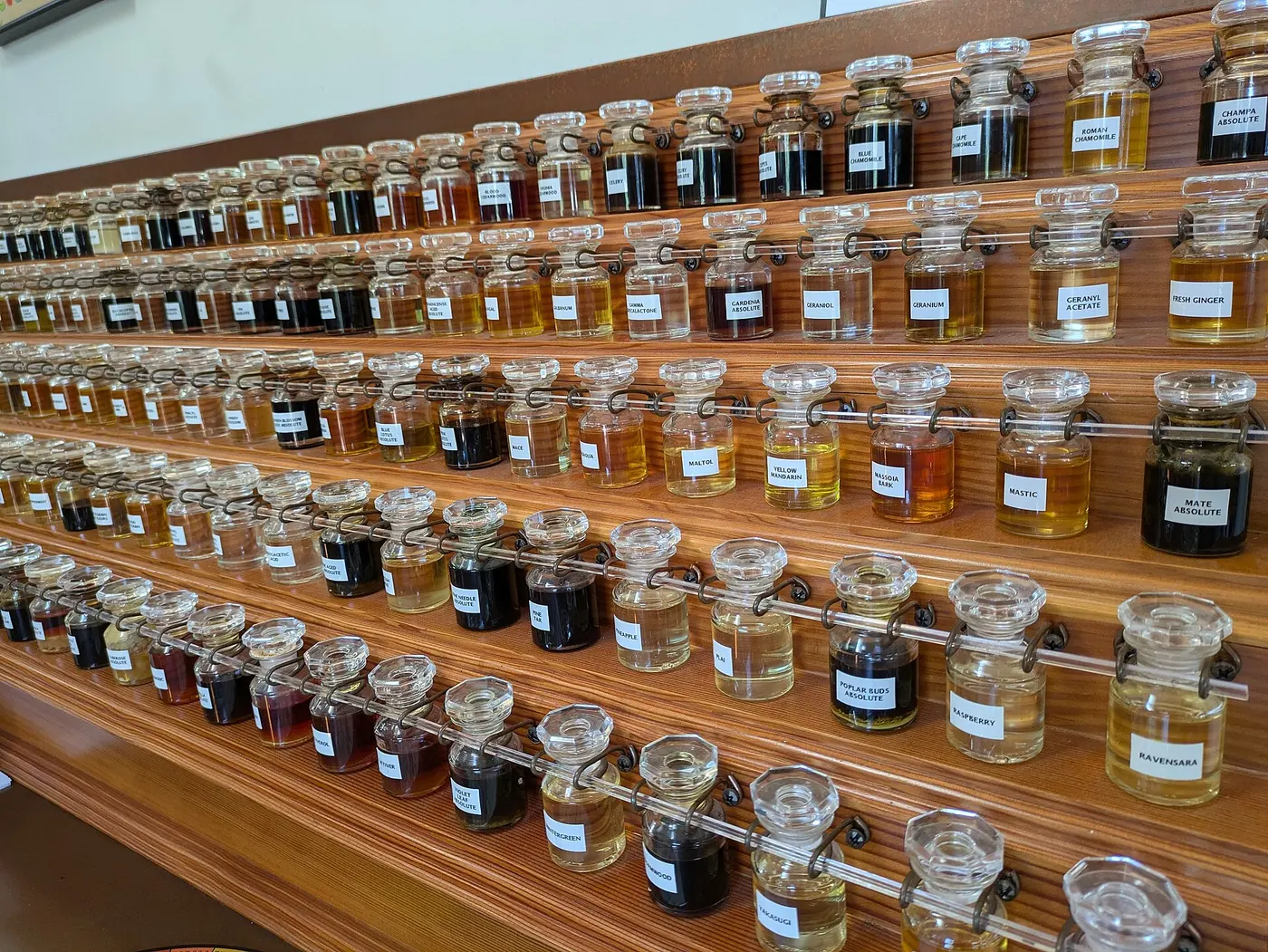 A perfumer’s workstation with rows of small fragrance bottles arranged on tiered shelves