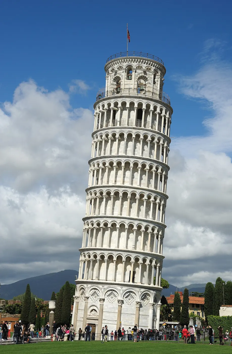A white marble cylindrical tower leaning sharply against a blue sky