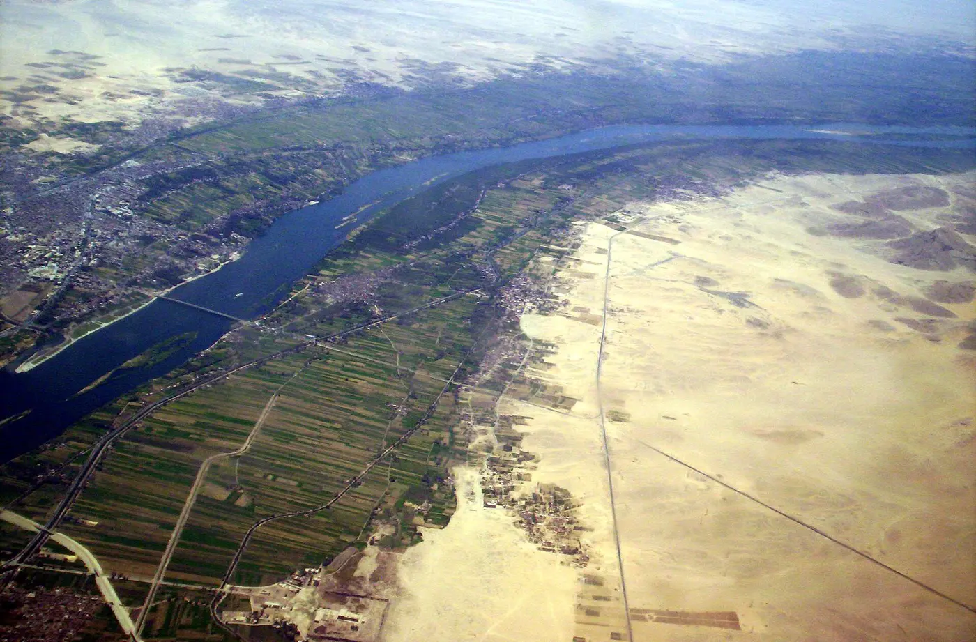 Aerial view of the blue Nile winding through the desert, with ribbons of green farmland along both banks