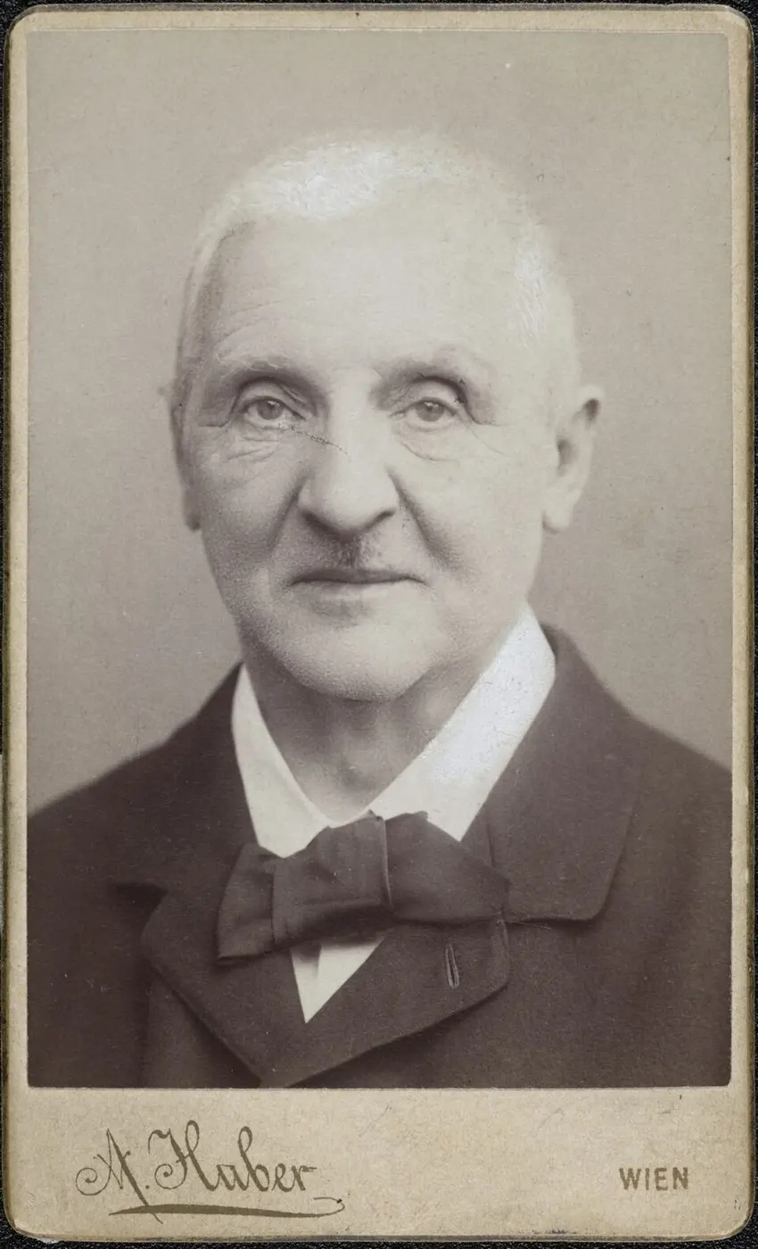 Portrait photo of an older man with close-cropped white hair and a bow tie