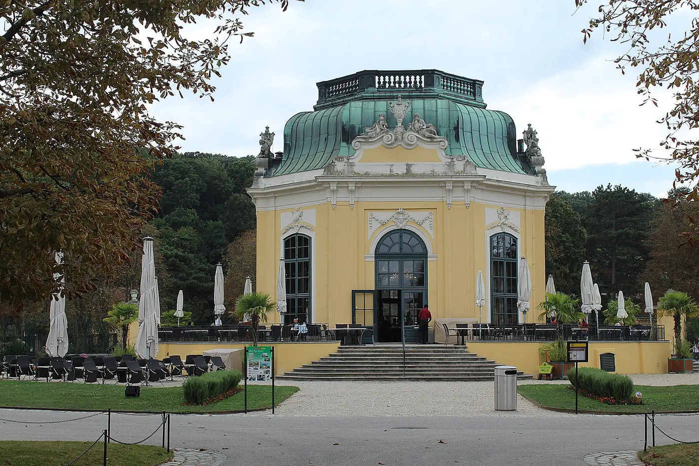 An elegant yellow octagonal building with a green roof