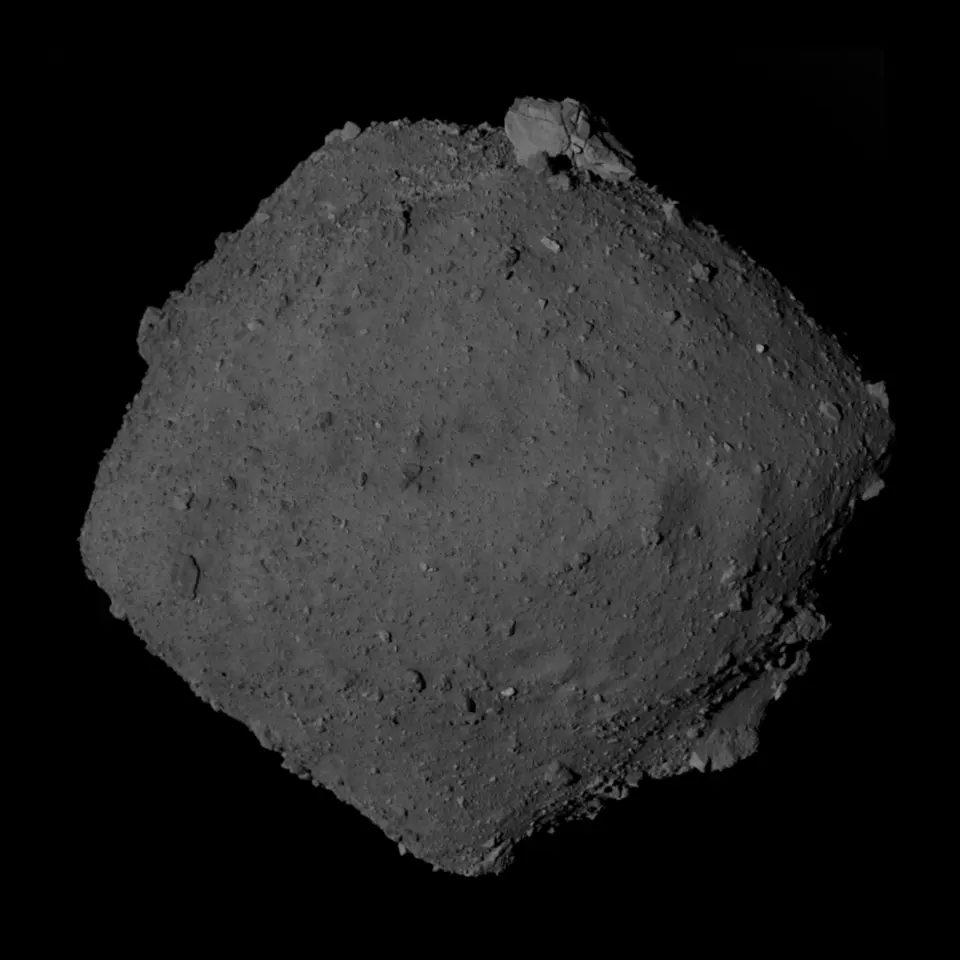 A dark, boulder-strewn asteroid shaped like an abacus bead, floating against the black of space