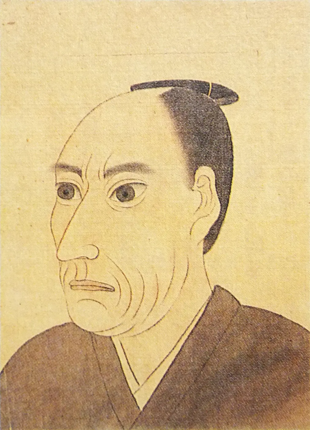 Portrait of a man with a topknot, in a kimono, his face and shoulders turned slightly to one side