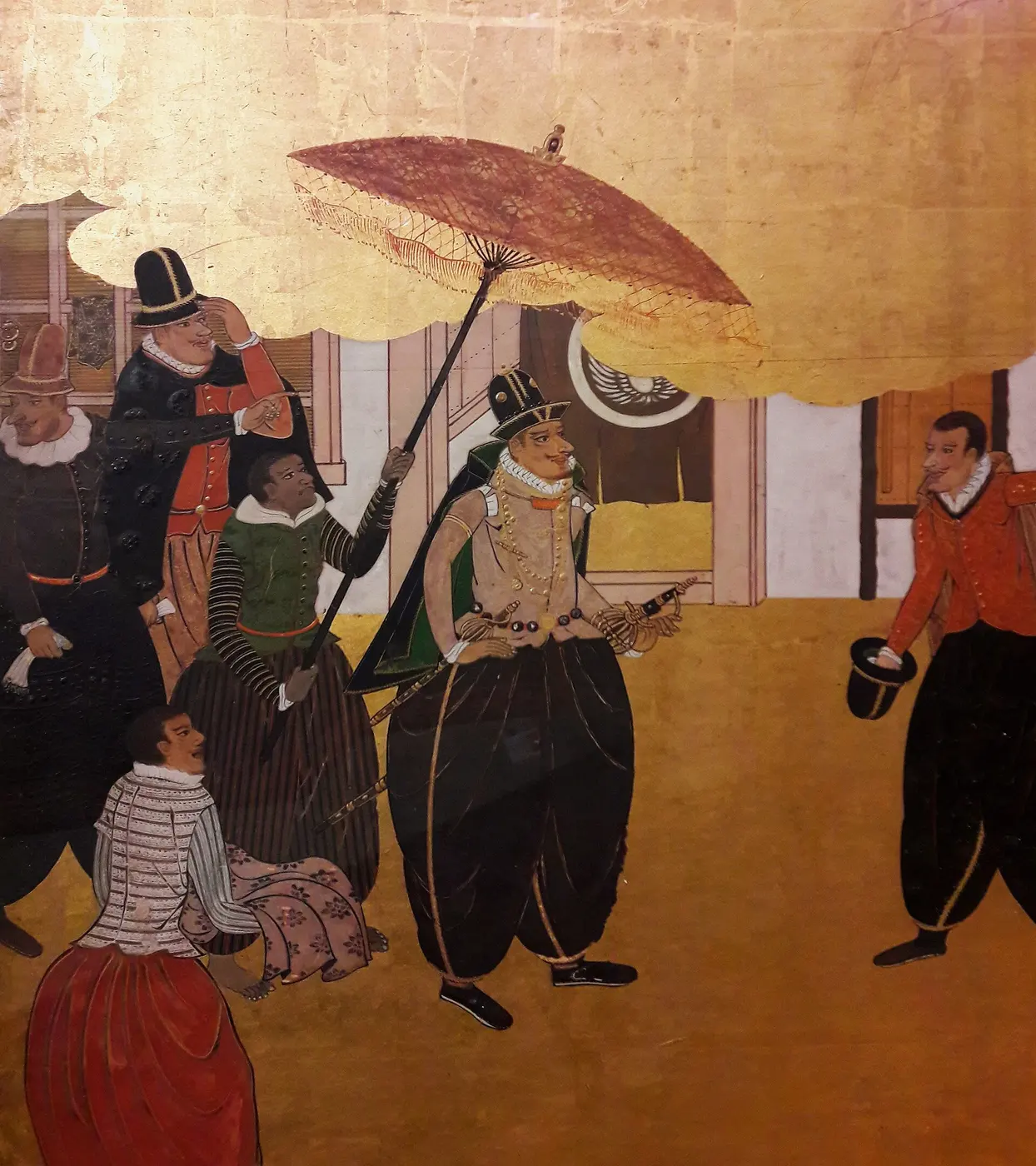 Detail of a folding screen showing a Portuguese man in a ruffled collar under a large parasol, with his attendants, against a gold background