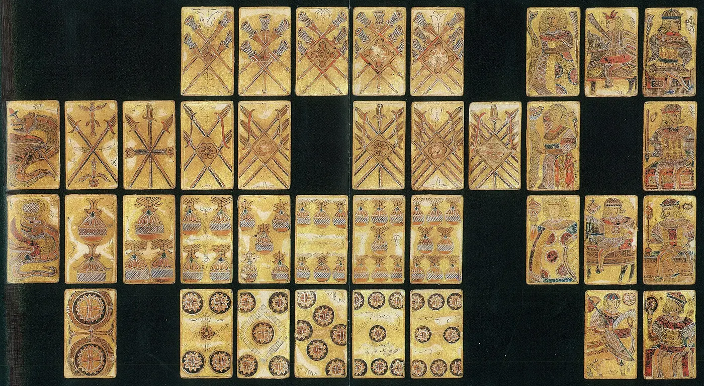 Gold-colored cards showing swords, cups, coins and figures, laid out on a black background
