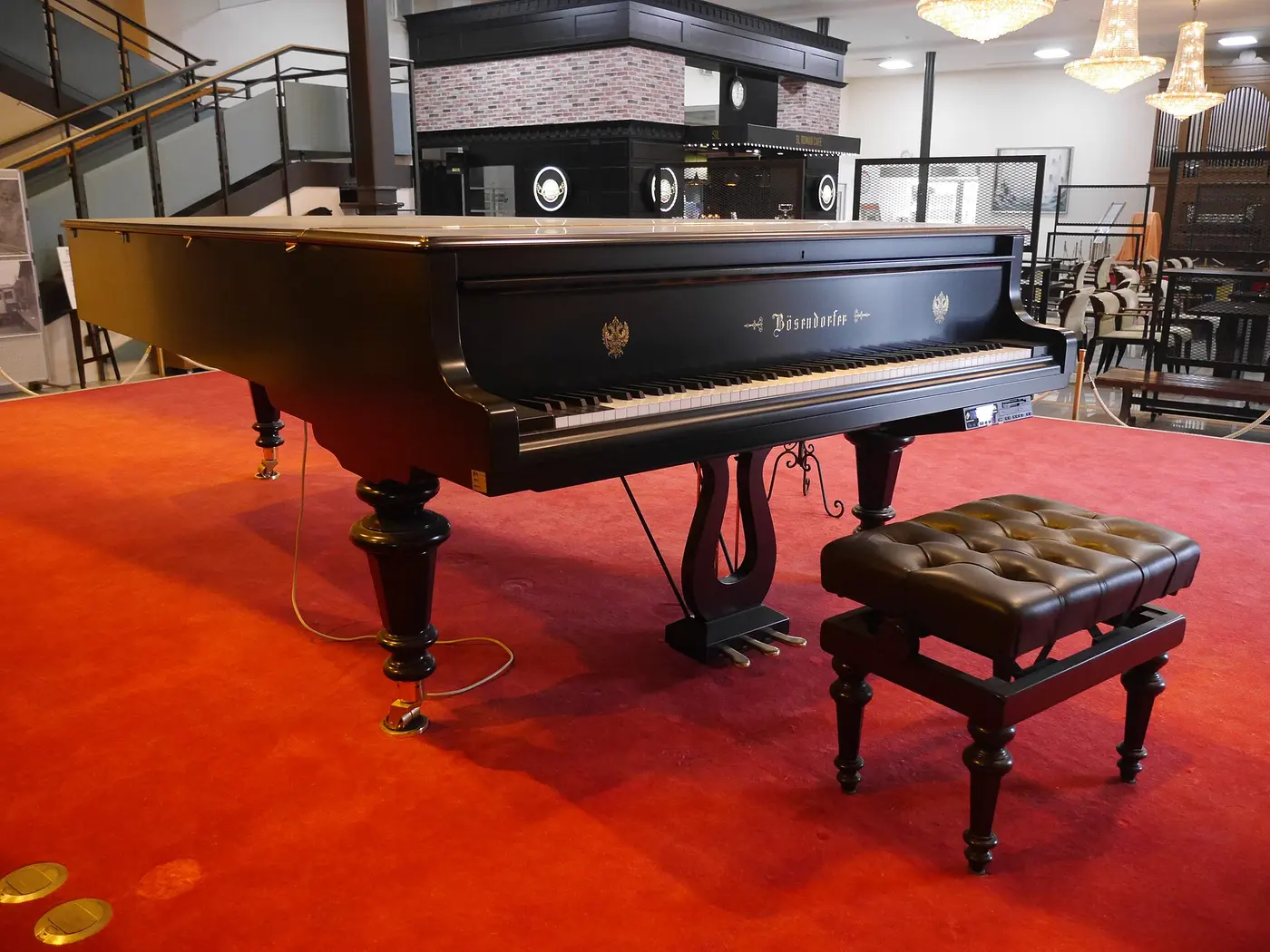 A large black grand piano standing on a red carpet