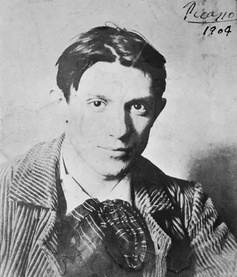 Black-and-white photo of a young Picasso in a striped jacket, with “Picasso 1904” written at the upper right