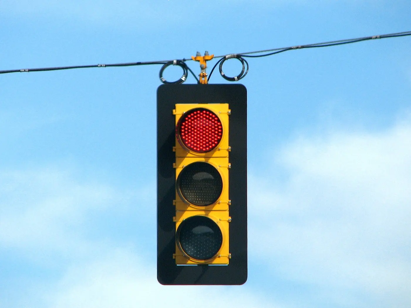 Close-up of a traffic signal with its red light lit