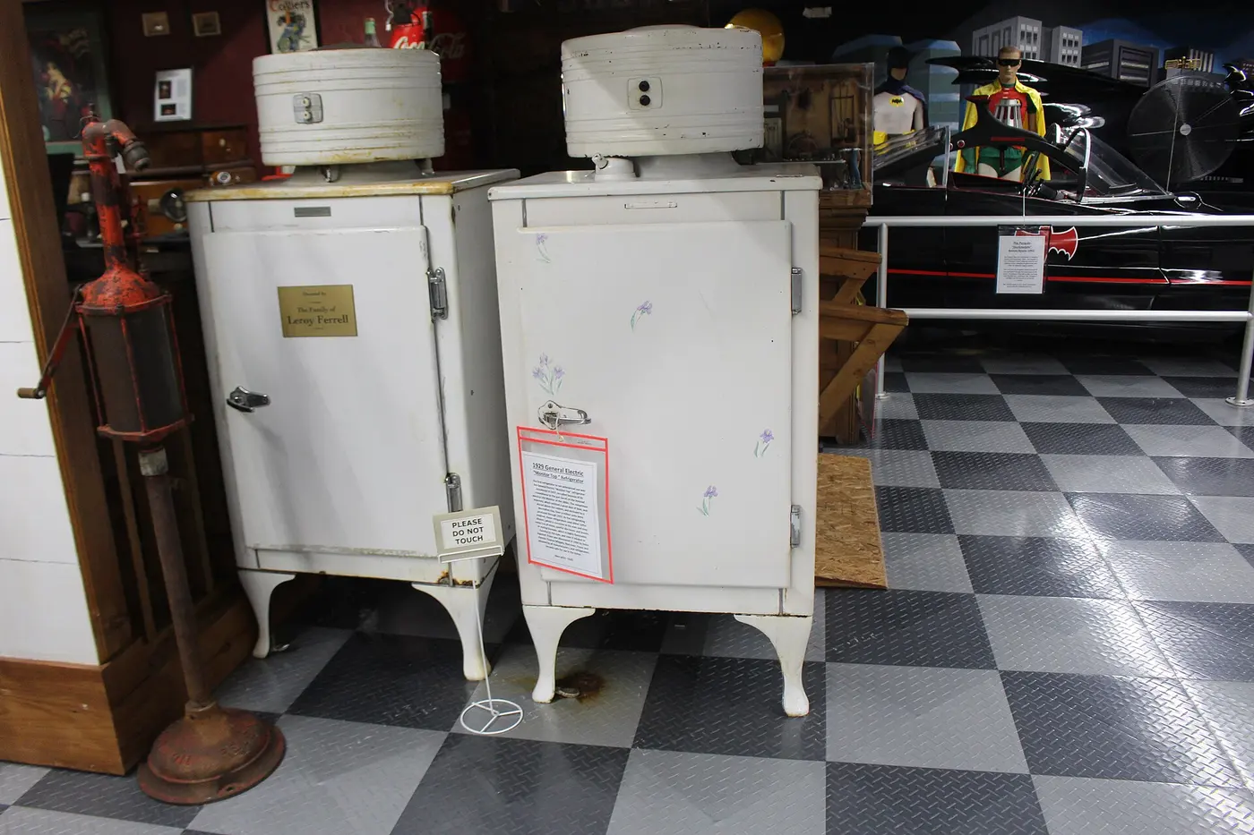 Two white box-shaped refrigerators on legs, each topped with a cylindrical machine
