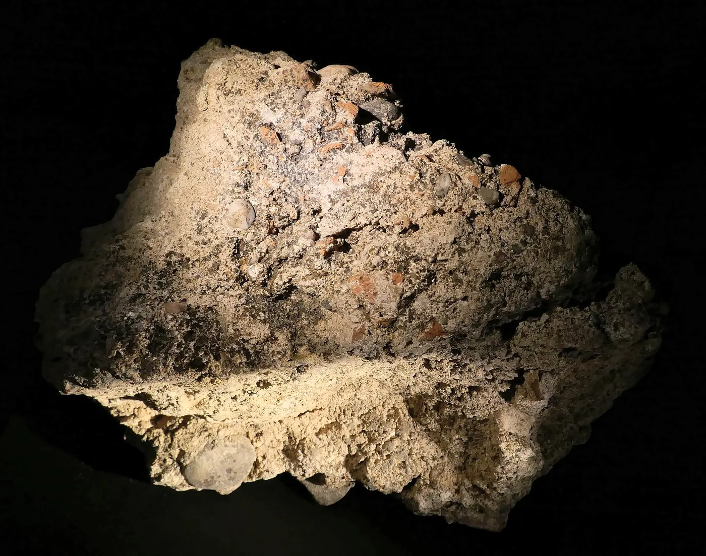 A lump of ancient Roman concrete with stone fragments of various sizes bound in mortar