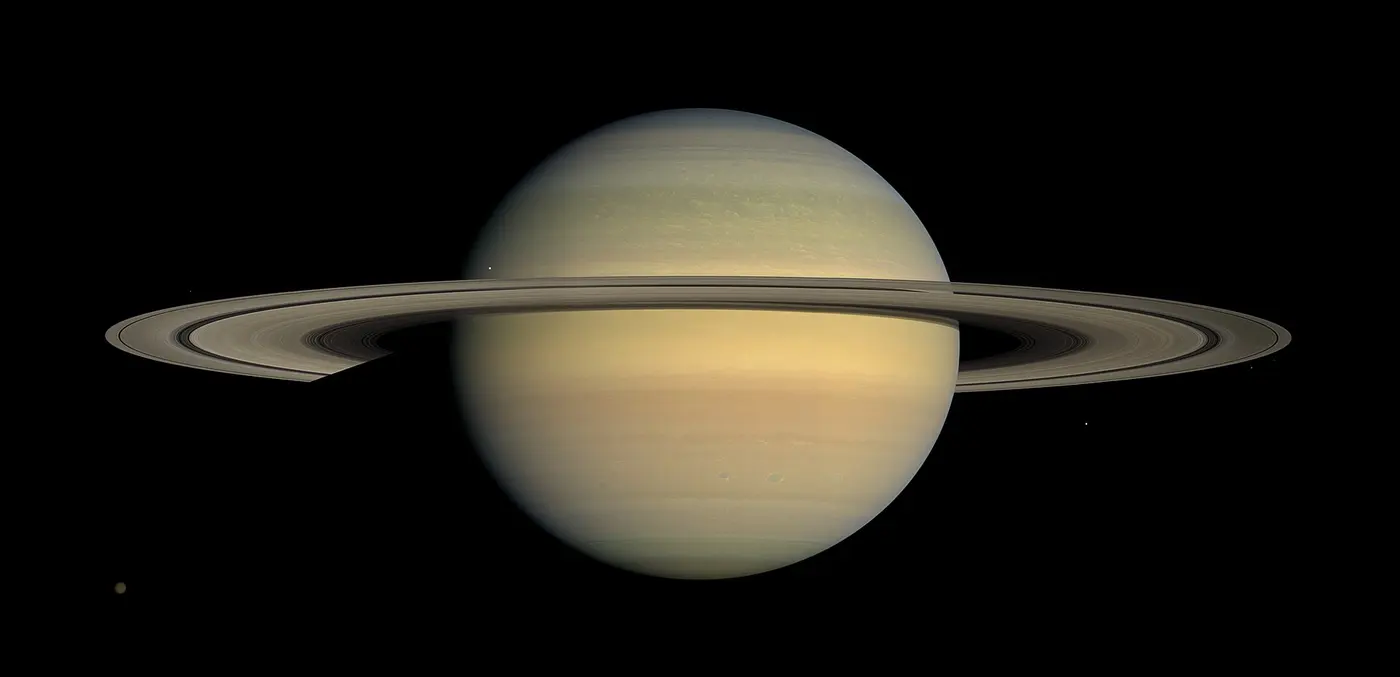 Saturn, slightly squashed and wider than it is tall, with its thin rings seen almost edge-on