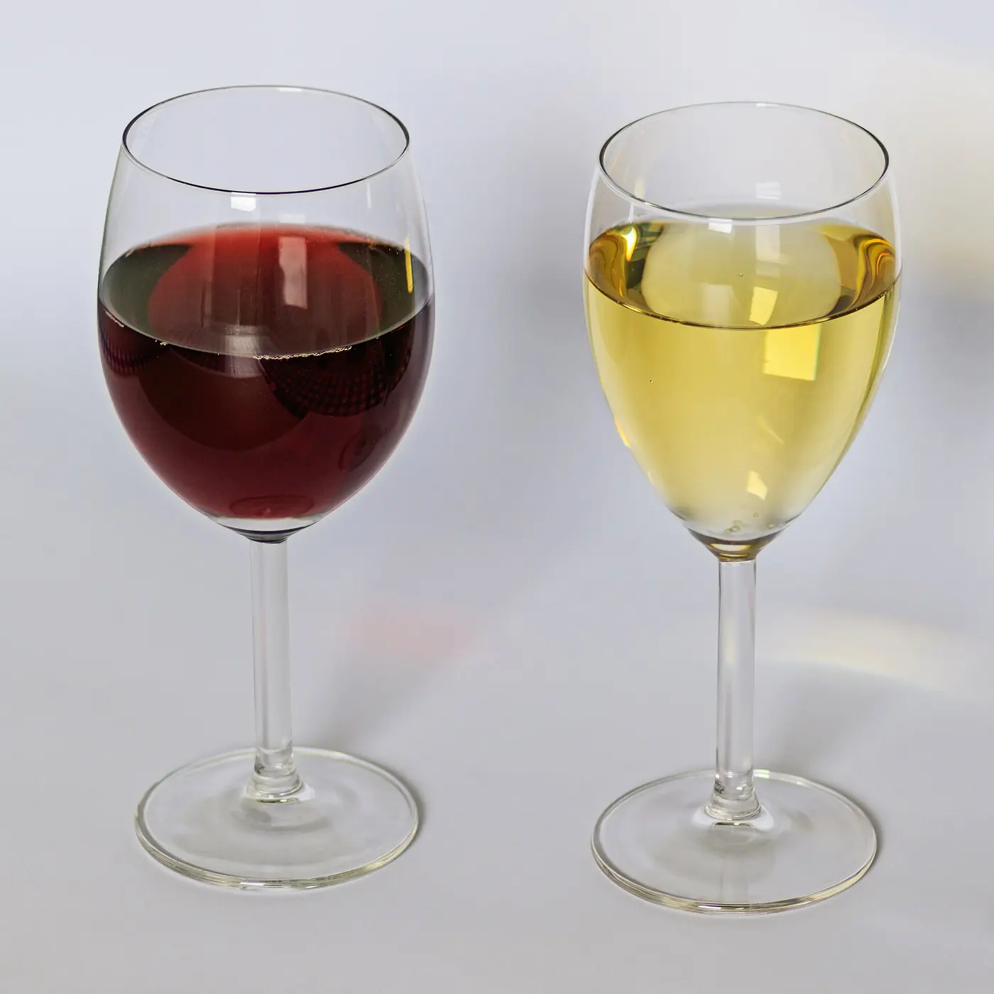 Two wine glasses, one filled with red wine and one with white wine