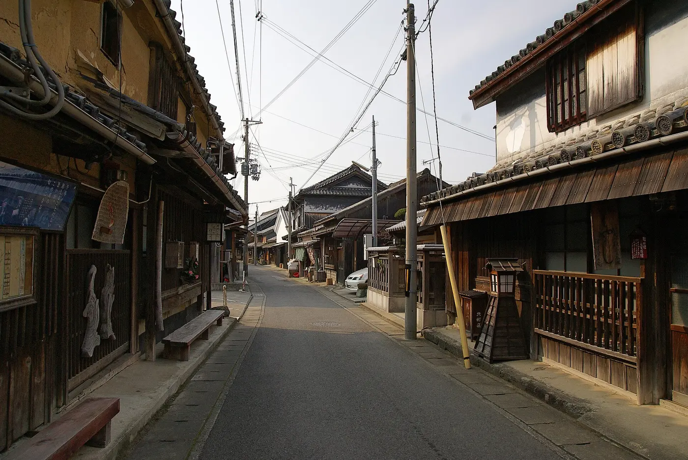 A narrow street lined on both sides with old wooden houses with tiled roofs and latticed fronts