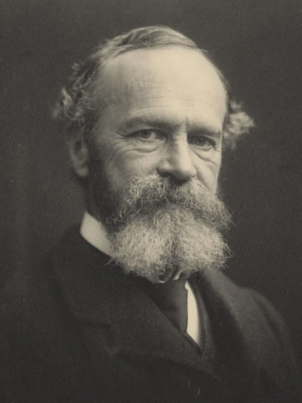 Black-and-white photograph of an older man with a white beard