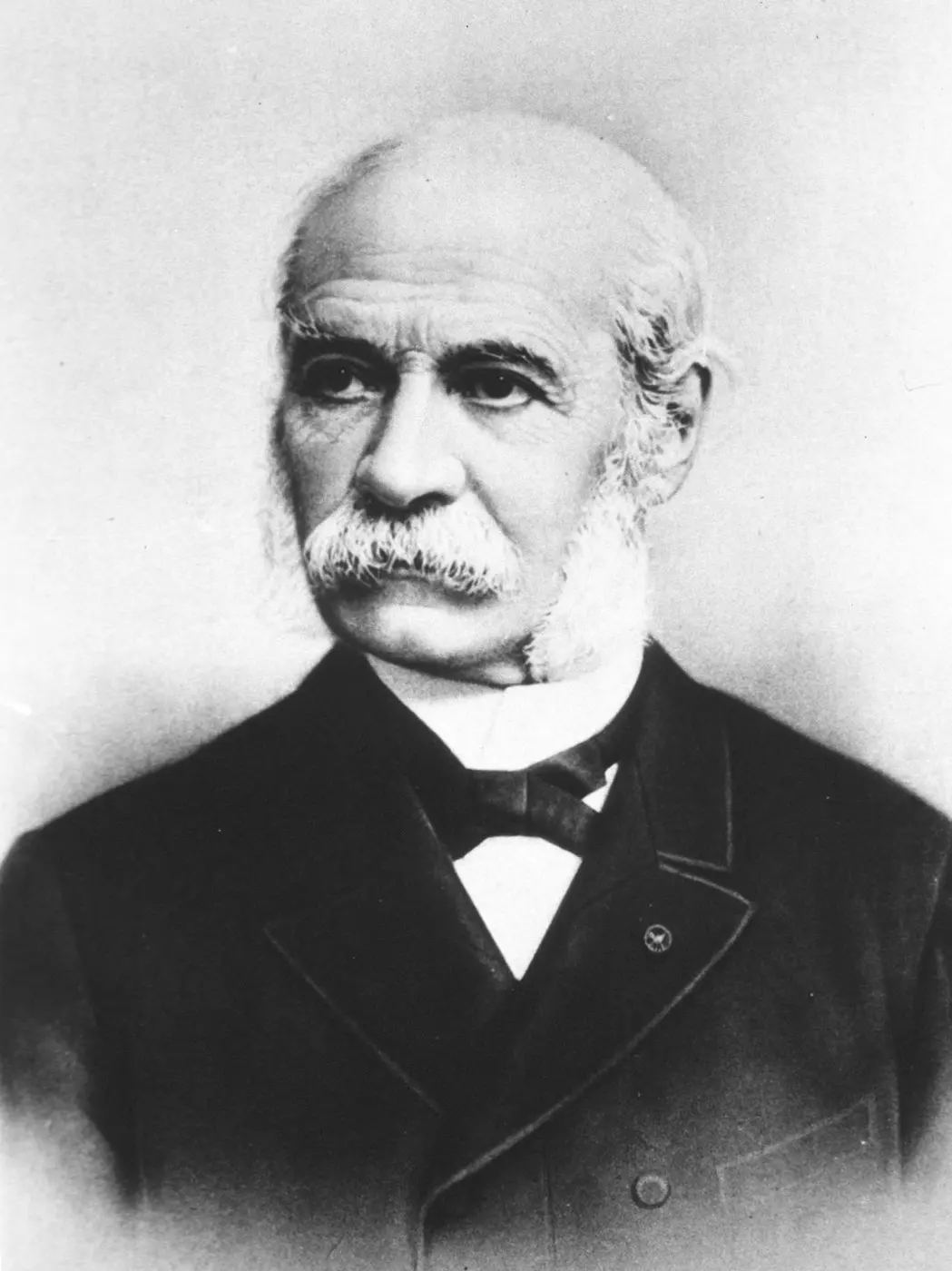 Portrait of an elderly man with a white mustache and side-whiskers, wearing a bow tie