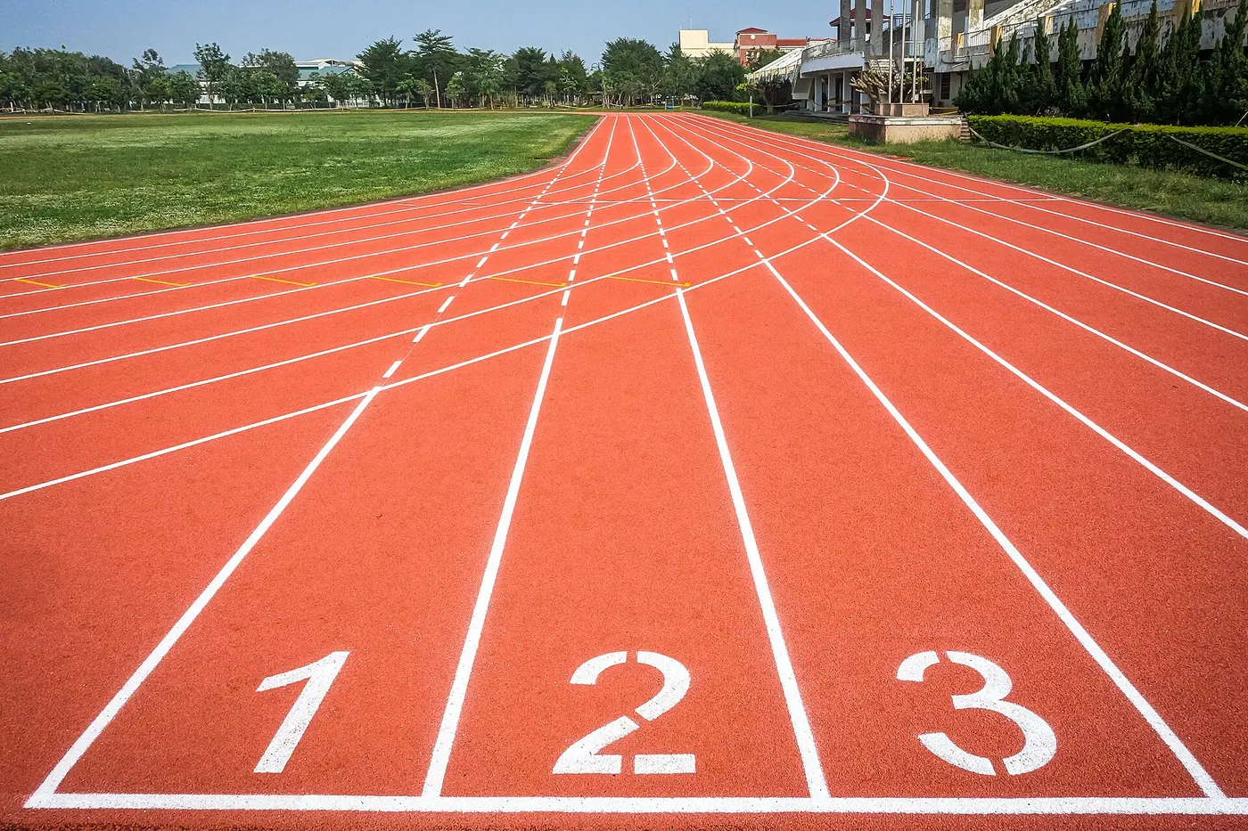 Red all-weather track lanes separated by white lines, curving away into the distance