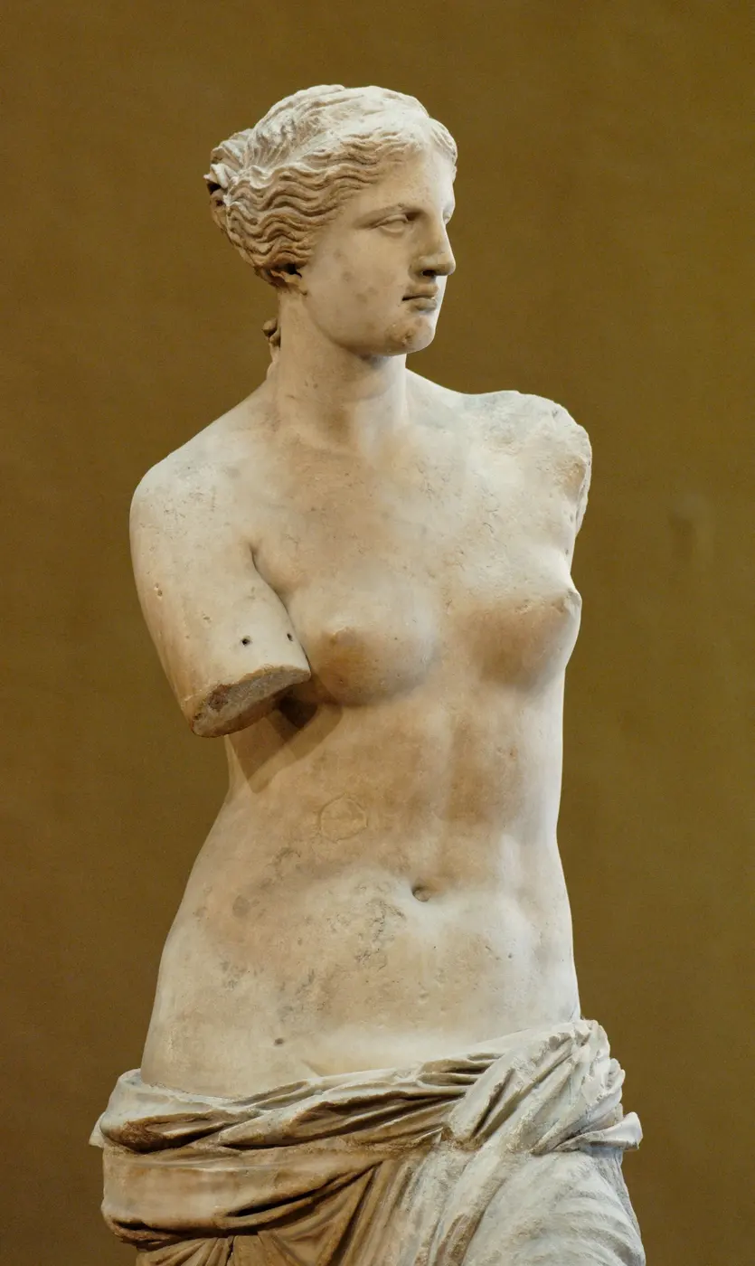 The upper half of a marble female statue, face turned to the right, both arms missing near the shoulders