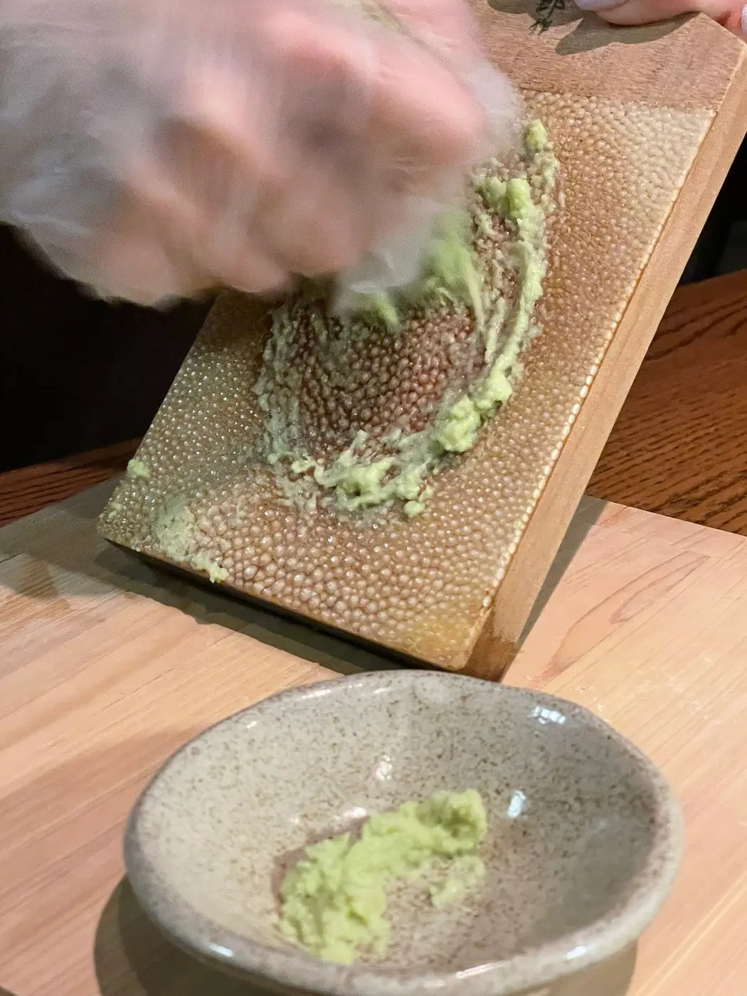 サメ皮のおろし器で本わさびの根茎をすりおろしているところ