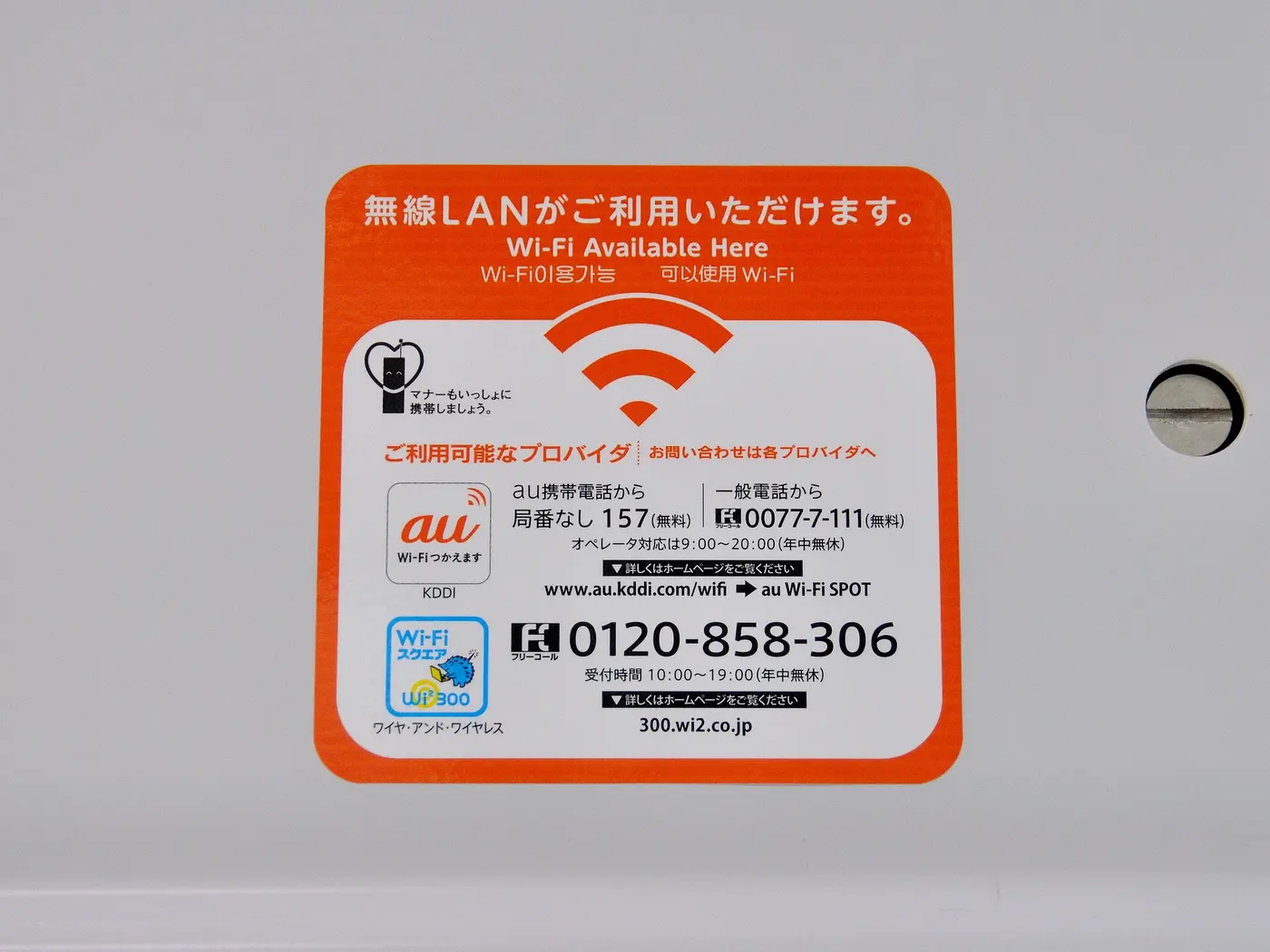 An orange sticker reading “無線LANがご利用いただけます。Wi-Fi Available Here” with a fan-shaped wireless signal icon